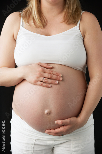 Close Up Portrait Of 9 months Pregnant Woman On Black Background © Monkey Business