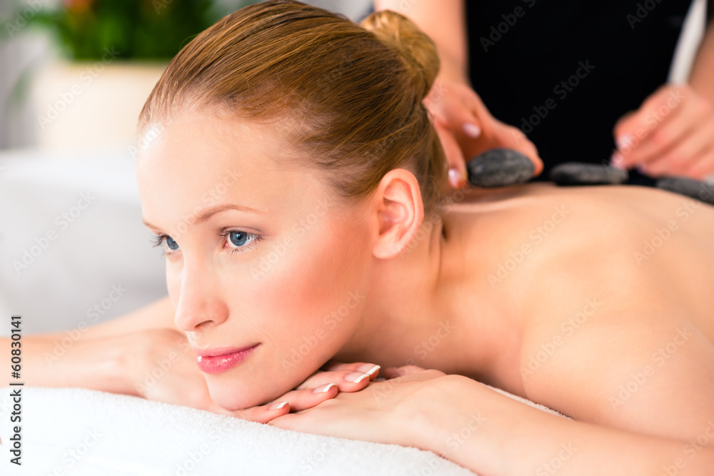 Frau bei Hot Stone Behandlung im Wellness Spa Frau bei Hot Stone Behandlung im Wellness Spa