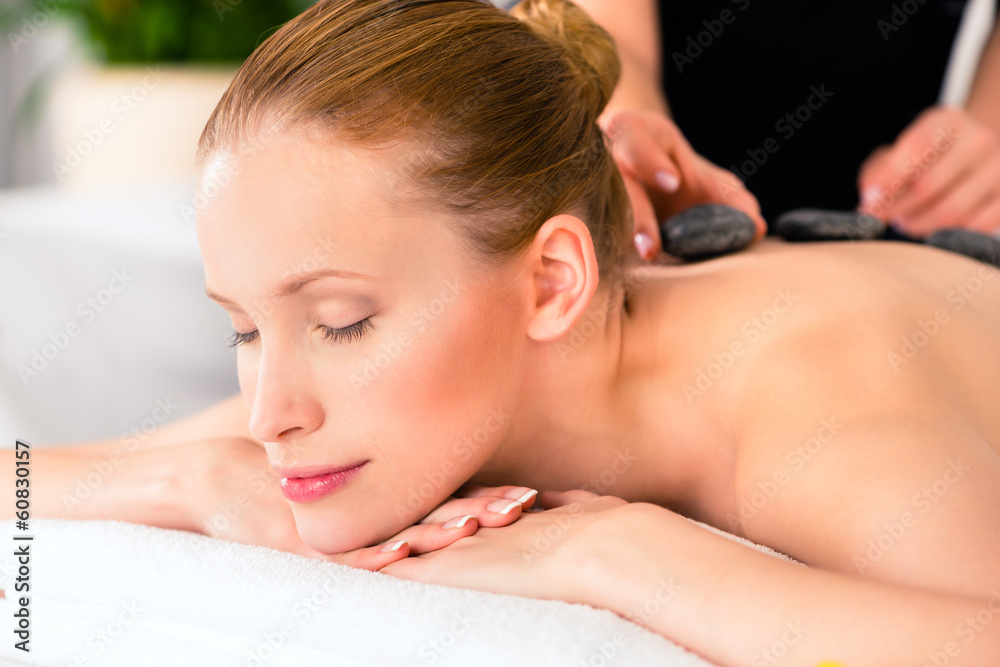 Frau bei Hot Stone Behandlung im Wellness Spa Frau bei Hot Stone Behandlung im Wellness Spa