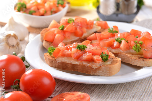 Delicious bruschetta with tomatoes on plate on table close-up