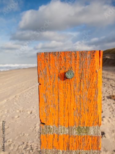 Beach post with sea level marker photo