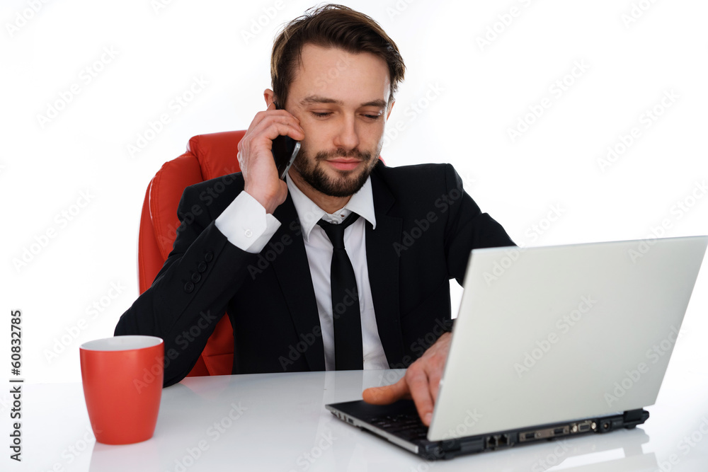 Businessman talking on his mobile at his desk Businessman talking on his mobile at his desk
