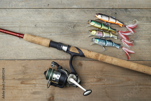 colorful lures with the fishing rod on the wooden pier