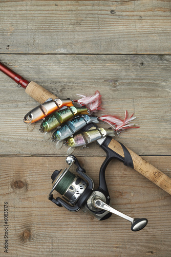 colorful lures with the fishing rod on the wooden pier