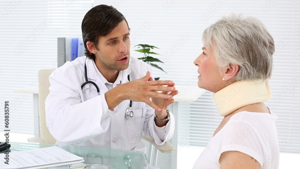 Doctor checking retired patient in neck brace Doctor checking retired patient in neck brace