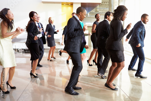 Businessmen And Businesswomen Dancing In Office Lobby