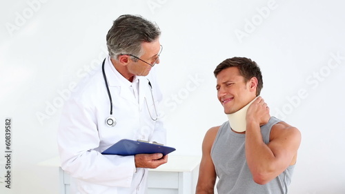 Sportsman in neck brace talking to doctor photo