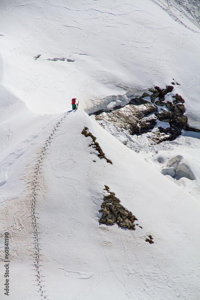 Fototapeta premium Skier climbing a snowy mountain