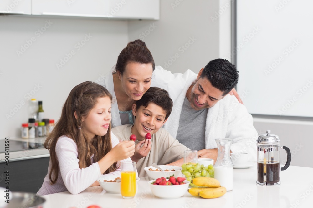 Happy kids enjoying breakfast with parents in kitchen Happy kids enjoying breakfast with parents in kitchen