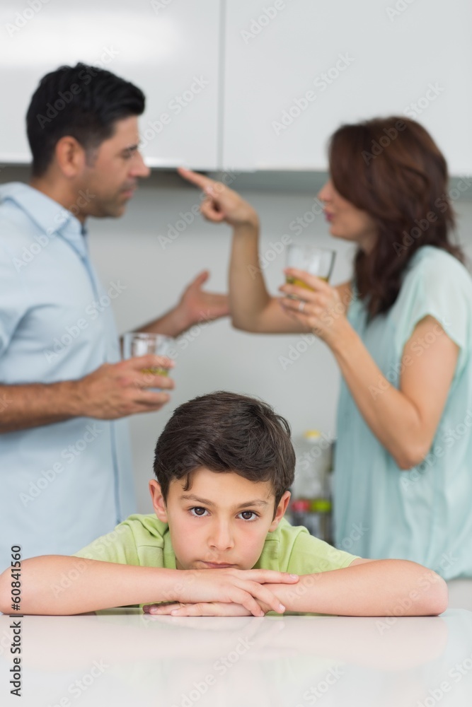 Portrait of a sad son while parents quarreling