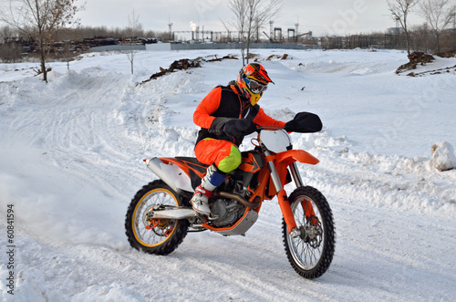 Winter motocross racer on a motorcycle rides in turn of
