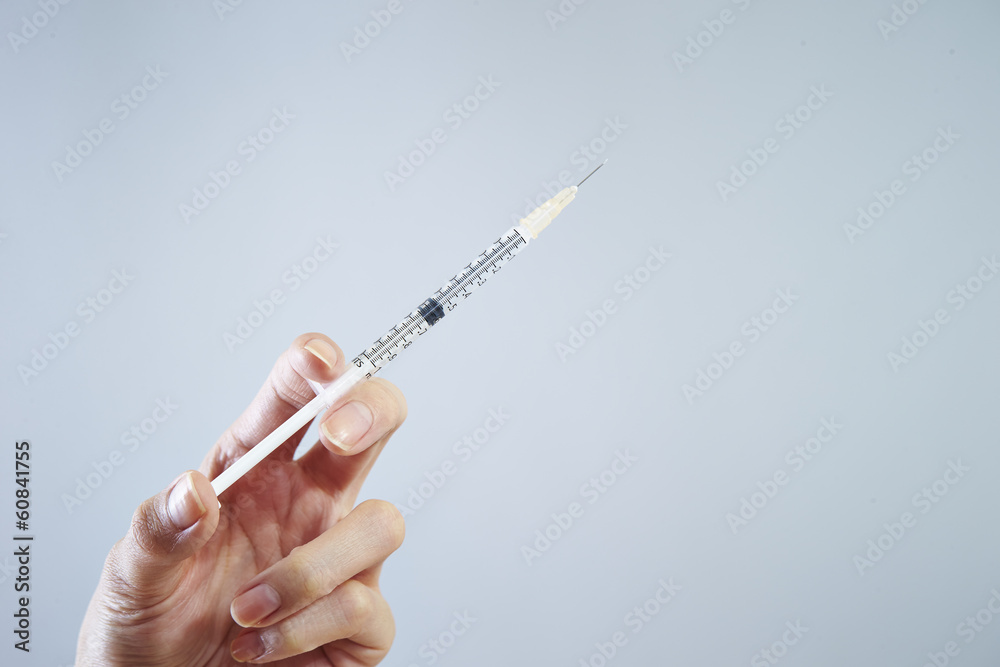 Hand holding syringe filled Hand holding syringe filled