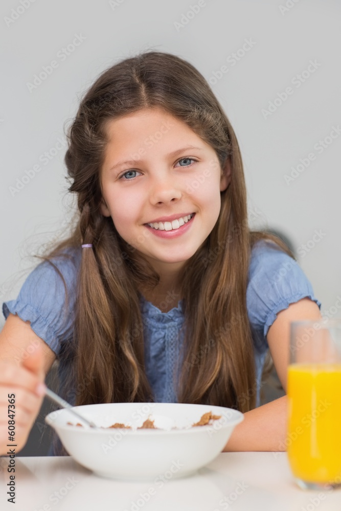 Smiling young girl enjoying breakfast in kitchen Smiling young girl enjoying breakfast in kitchen