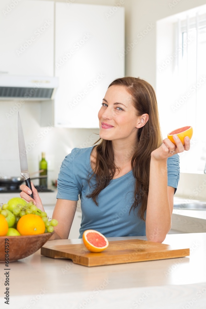 Woman with fruit bowl on counter in kitchen Woman with fruit bowl on counter in kitchen