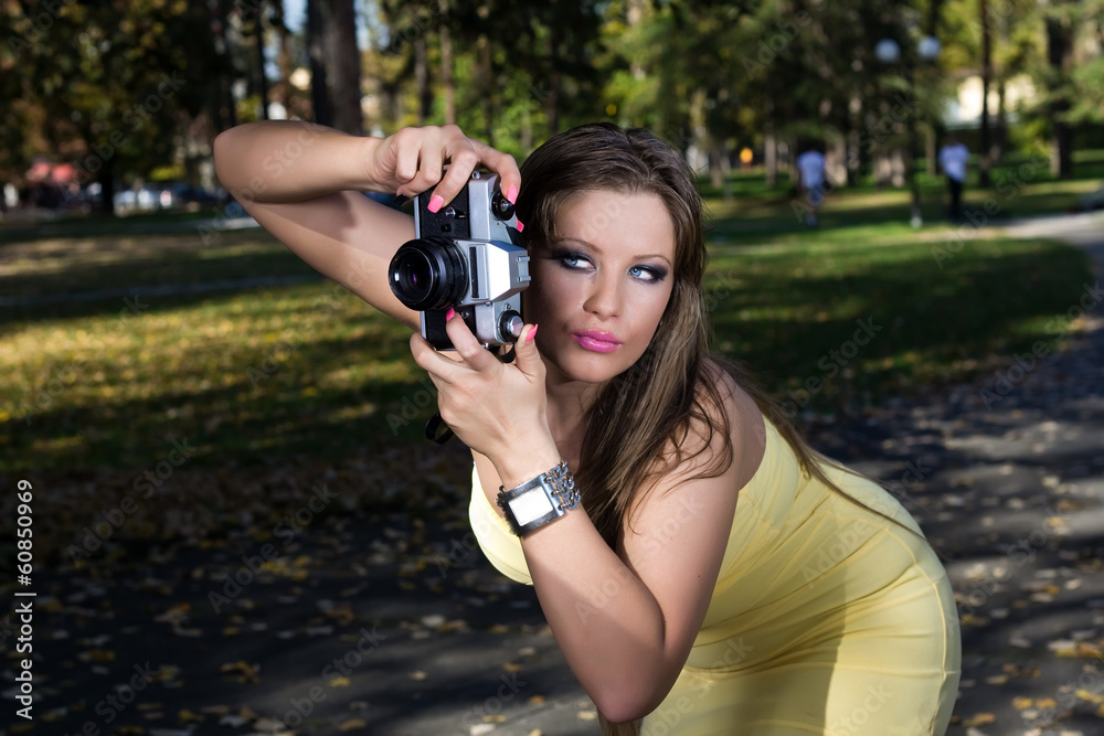 Beautiful woman photographing summer park Beautiful woman photographing summer park