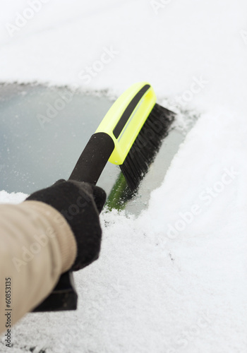 closeup of man cleaning snow from car