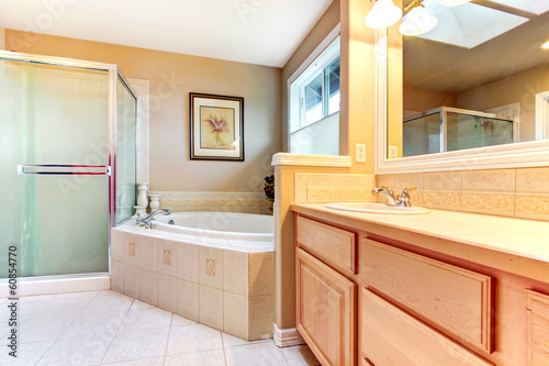 Refreshing bathroom with light wood cabinets, glass shower and b