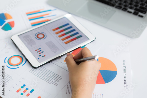 Close-up of business person using digital tablet with financial