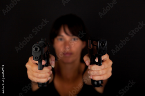 Woman aiming two guns © ijdema