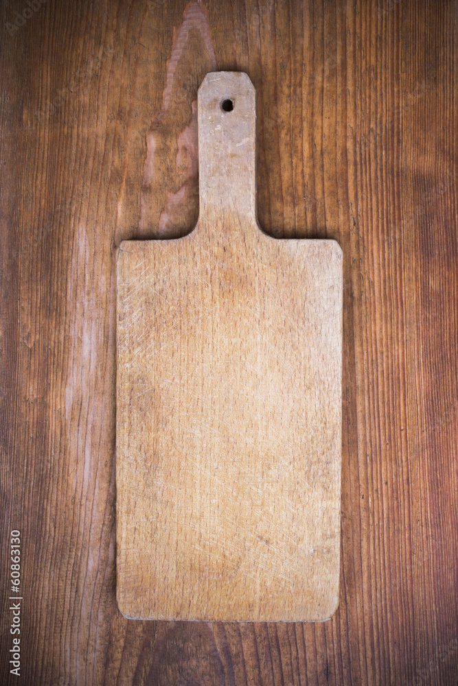 old wooden cutting board on a wooden background old wooden cutting board on a wooden background