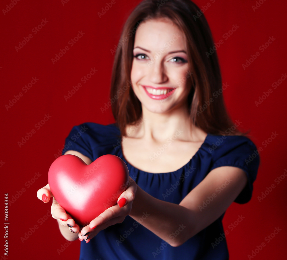 Attractive woman with heart, on red background Attractive woman with heart, on red background