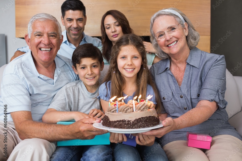 Portrait of extended family with cake in living room