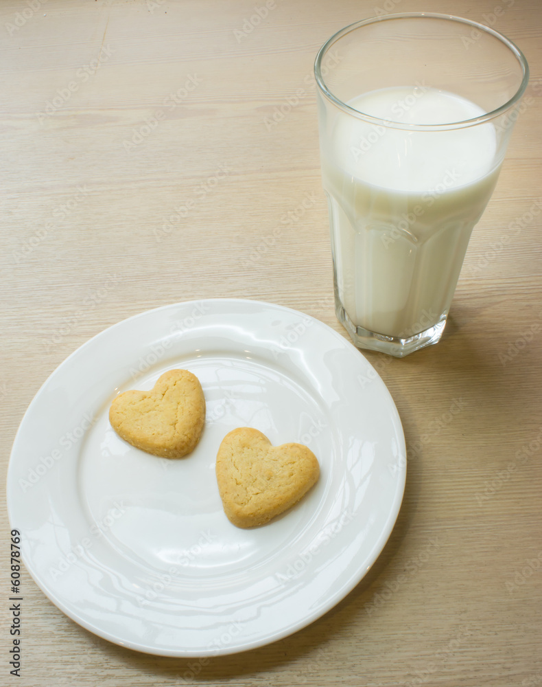 Heart cookies on white plate and glass of milk. Heart cookies on white plate and glass of milk.