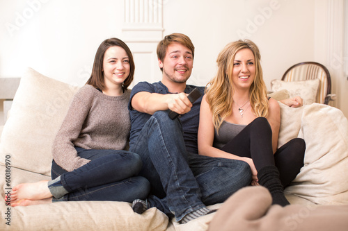 Three teenage friends sitting watching television