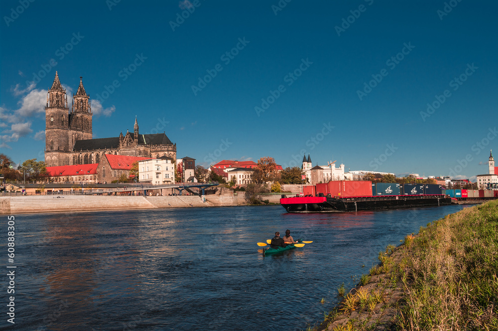 Cathedral of Magdeburg at river Elbe, barge and canoeing