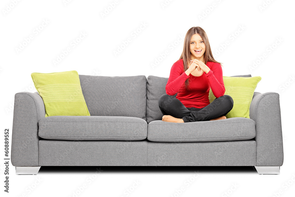 Smiling girl sitting on a sofa and looking at camera Smiling girl sitting on a sofa and looking at camera
