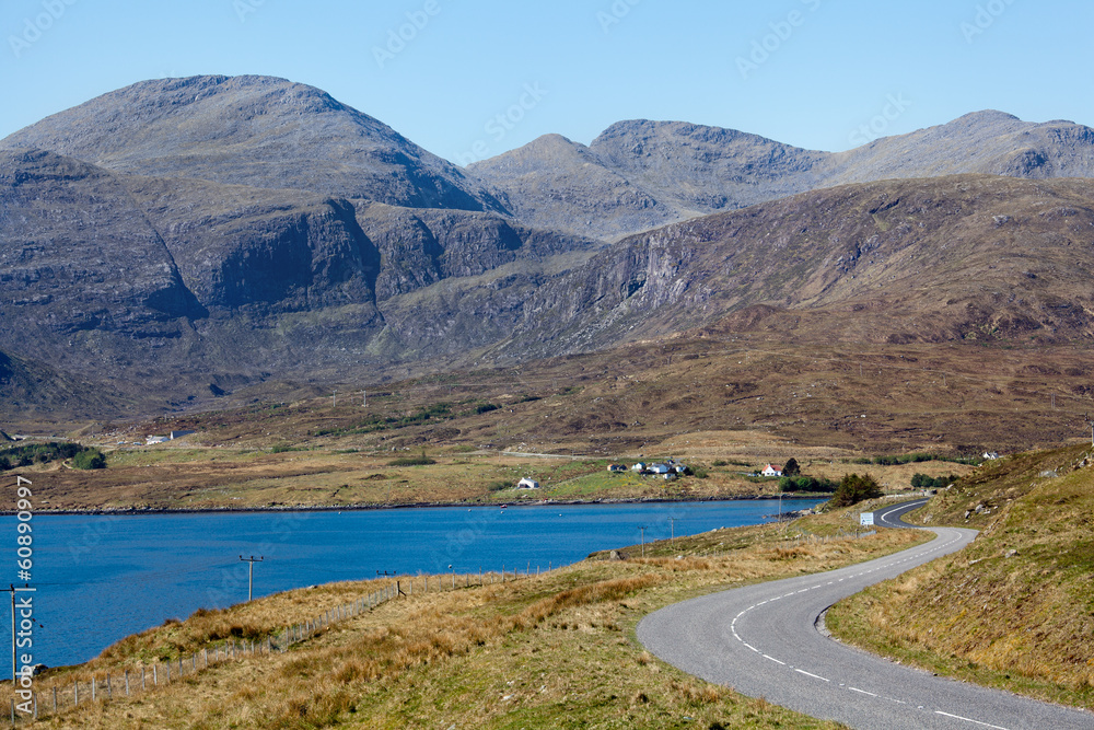 Desert road running through mountains with lake