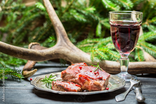 Red wine in a glass and venison on a plate photo