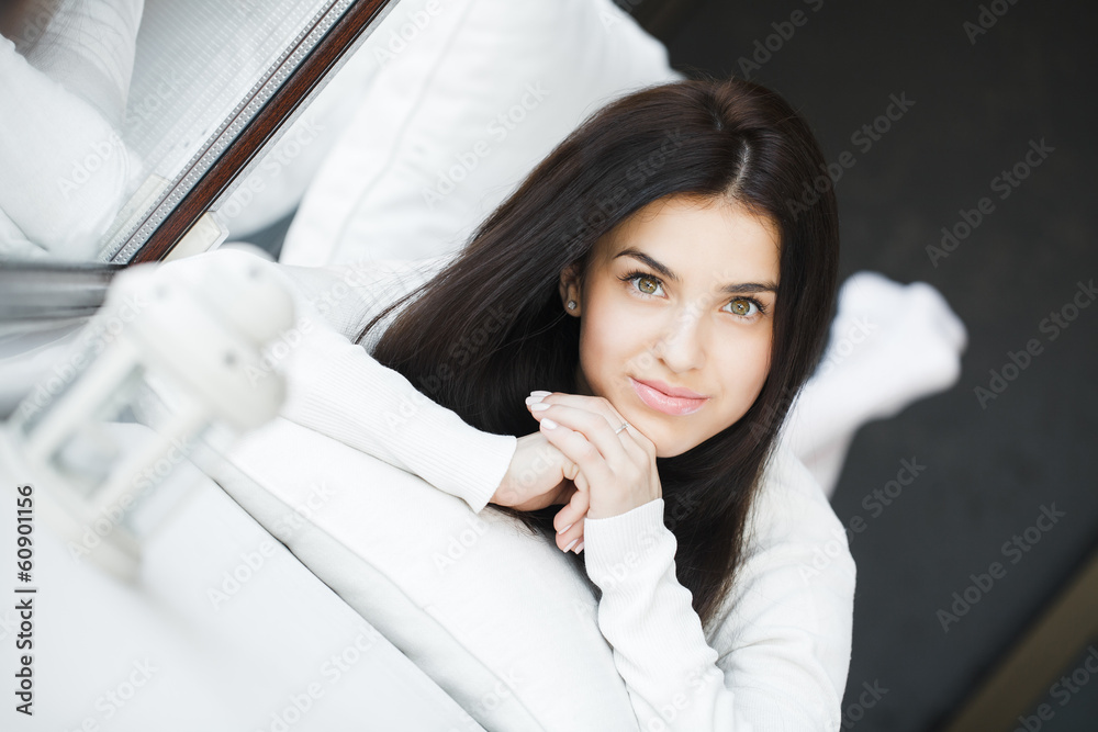 portrait of young beautiful woman on a sofa near the window portrait of young beautiful woman on a sofa near the window