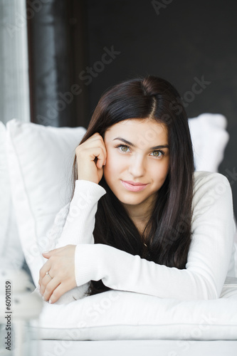 portrait of young beautiful woman on a sofa near the window © GTeam