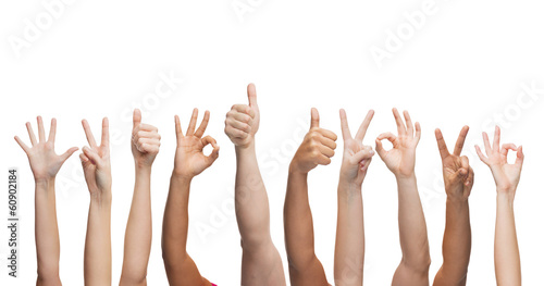 human hands showing thumbs up, ok and peace signs
