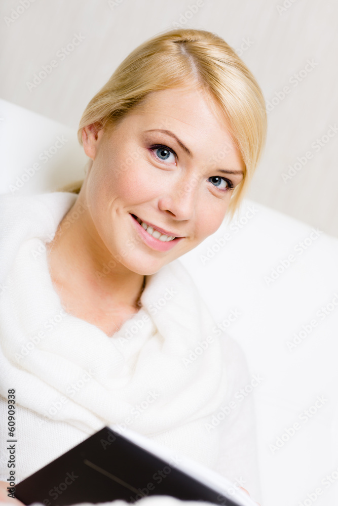 Woman in white sweater holds the book 