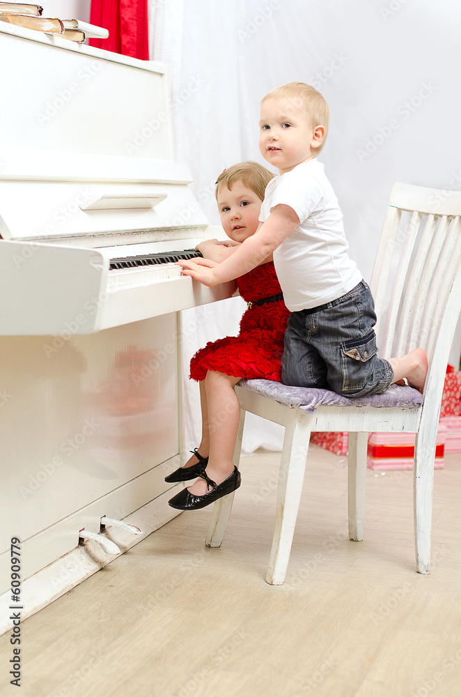 boy and girl playing on white piano boy and girl playing on white piano