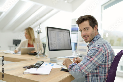 Smiling office worker sitting at desk