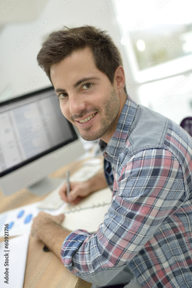 Smiling office worker sitting at desk Smiling office worker sitting at desk