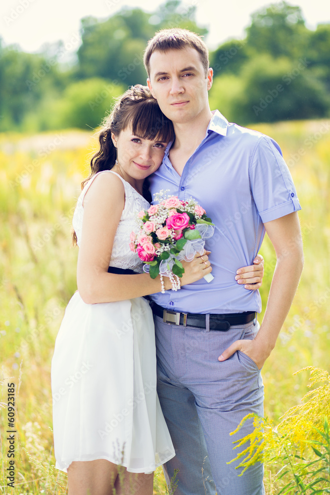 portrait of a boy and a girl with a bouquet of standing against portrait of a boy and a girl with a bouquet of standing against