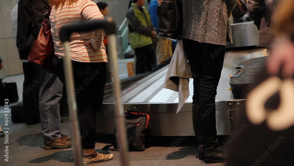 Travellers at the airport waiting for their luggage.
Travellers at the airport waiting for their luggage.