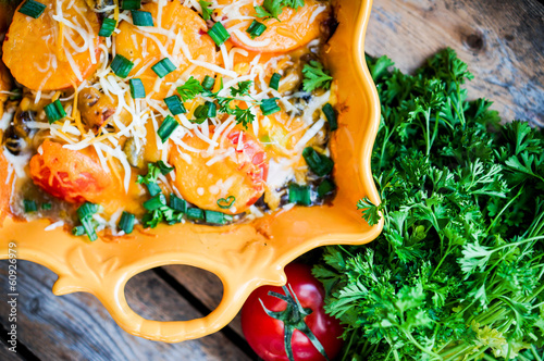 Baked vegetables in a dish on wooden background