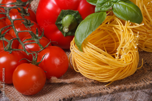 Branch of ripe tomatoes, dried pasta, fresh basil and pepper