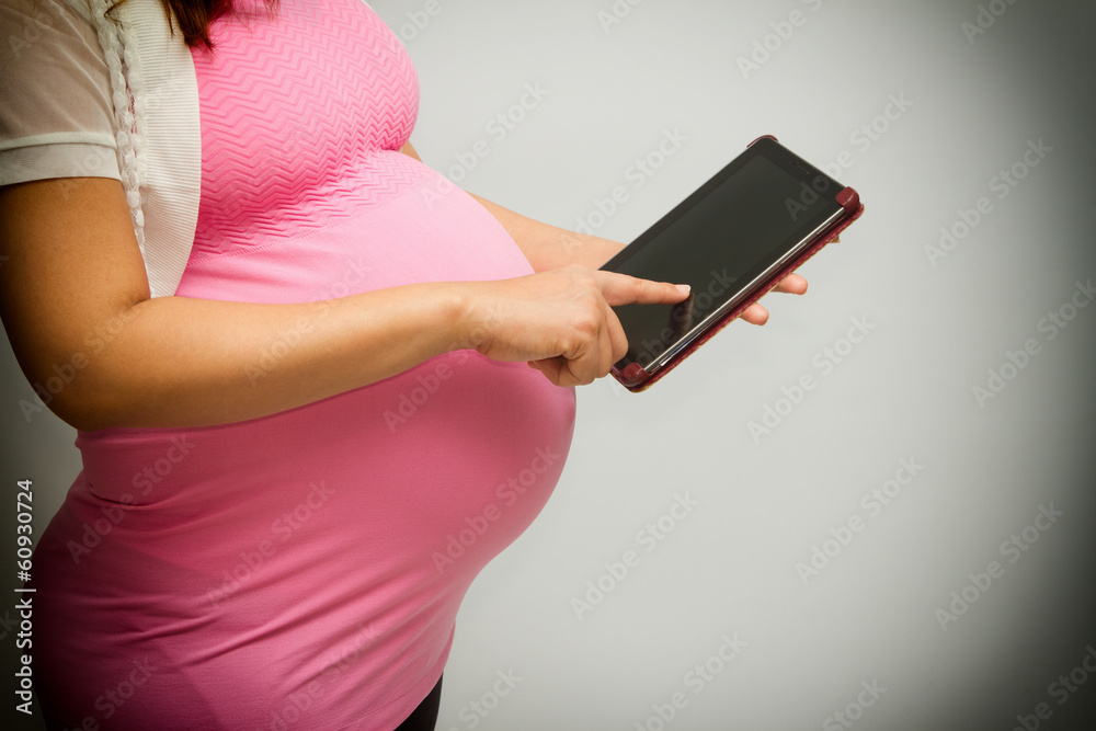 pregnant woman using a tablet pc pregnant woman using a tablet pc