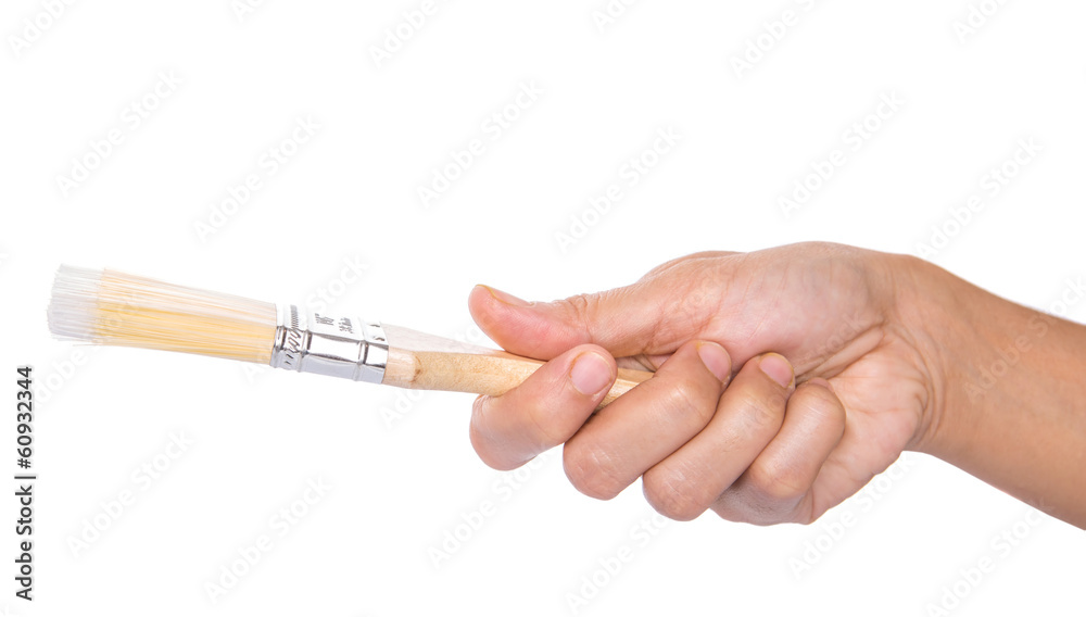 Female hand holding a paint brush over white background Female hand holding a paint brush over white background