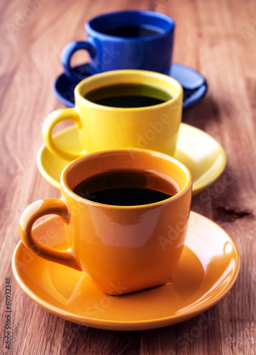 Colorful coffee cups on a wooden background.