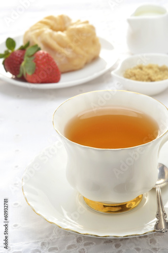 Tea with glazed cruller and strawberries