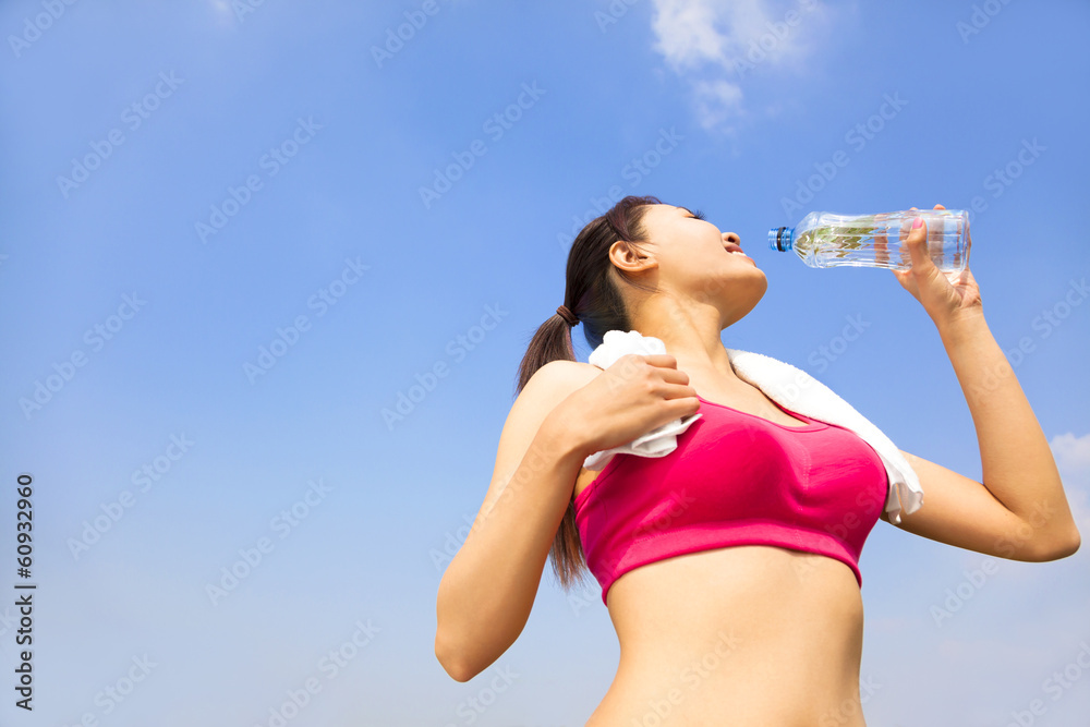 sporty woman drinking water bottle after jogging or running sporty woman drinking water bottle after jogging or running