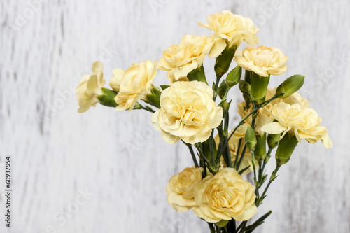 Yellow carnation flowers isolated on white wooden background