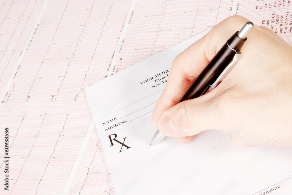 Doctor filling in empty medical prescription on ECG Doctor filling in empty medical prescription on ECG